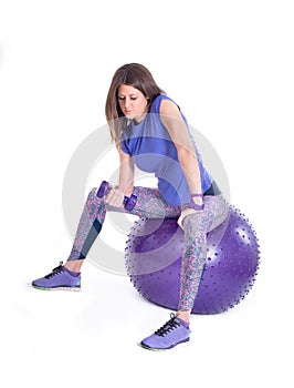 Sport woman with a pilates ball and dumbbells