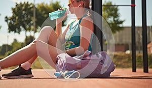 Sport woman relaxing after workout at the stadium, runner taking break after running sport.