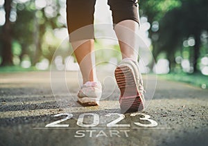 Sport woman runner foot shoe start into the new year 2023. Start up of runner woman running on nature race track go to Goal of