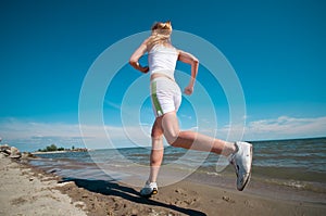 Sport woman running in sea coast