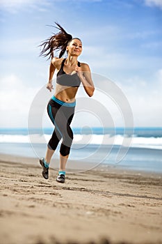Sport woman running in sea coast on sunny day