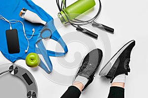 Sport woman sitting and resting after workout or exercise in fitness gym with protein shake or drinking water on floor