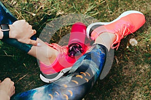 Sport woman sitting and resting after workout or exercise in fitness gym with protein shake or drinking water on floor. Relax