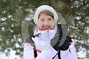Sport woman with a smartphone in pine winter forest