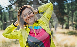Sport woman smiling  in nature, Relaxing activity with stretch arms. Young fit woman doing stretching exercises training outside