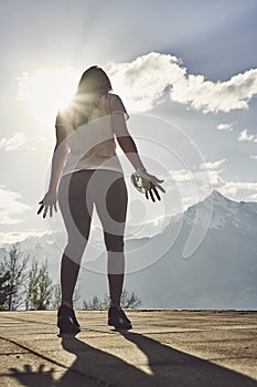 Sport woman in sunny evening mountains