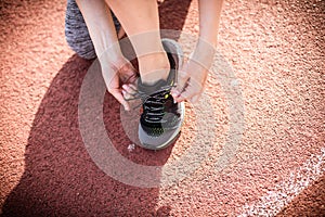 Sport woman tying her shoe. Close up image.