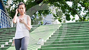 Sport woman using mobile phone running in city urban building