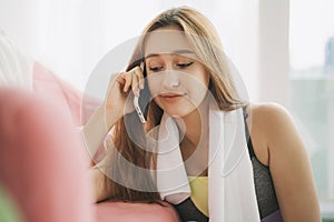 Sport woman using phone after work out at home