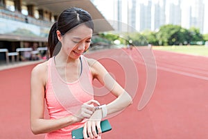 Sport woman using wearable smart watch in sport stadium