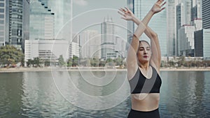 Sport woman wearing wireless headphones and stretching muscles before running in city, warmup exercise