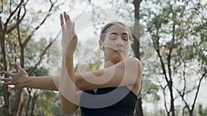 Sport woman wearing wireless headphones and stretching muscles before running in city, warmup exercise