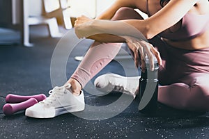 Sport woman workout at fitness center with relax and taking a break Beautiful girl holding protein shake bottle after exercise at