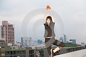 Sport women stretch working on the top of building twilight