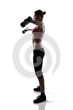 Sport young athletic woman doing exersise with dumbbells, silhou