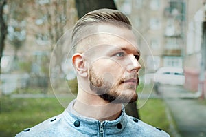 Sport young man with a modern trendy fade profile haircut for barbershop