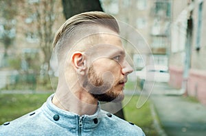 Sport young man with a modern trendy fade profile haircut for barbershop