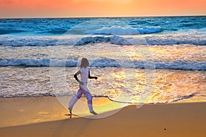 Sporting woman is engaged in run on the sea coast on a beach.Sea tropical landscape