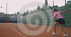 Sportiv woman playing professional tennis on the tennis court , sunny day outside.