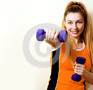 Sportive athletic woman working out with dumbbells