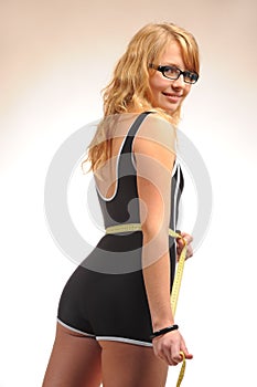 Sportive blonde girl with measuring tape