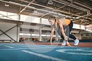 Sportive blonde woman training at indoor stadium