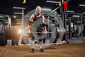 Sportive bodybuilder with barbell in gym