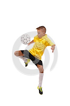 A sportive boy kicking a soccer ball. A little kid in a football uniform isolated on a white background. Sports concept.