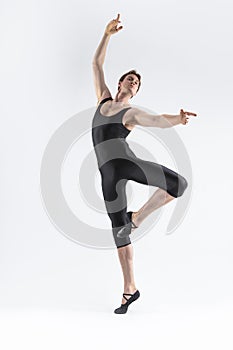 Sportive Caucasian Male Ballet Dancer Flexible Athletic Man Posing in Black Tights in Ballanced Dance Pose With Hands and Leg