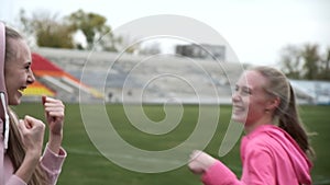 Sportive caucasian twins in sportswear have fun, pretend to box, fight, laugh