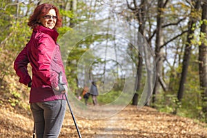 Sportive cute woman Nordic walking autumn cross country