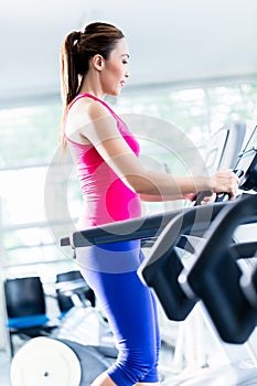 Sportive girl doing workout on treadmill