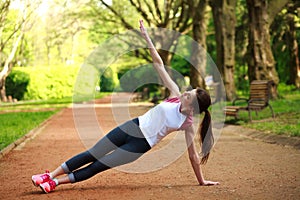 Sportive girl exercising outdoor in park, fitness training