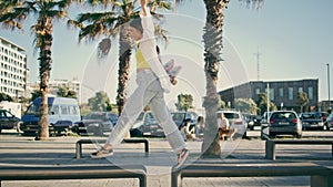 Sportive girl holding skateboard crossing benches. Woman waiting friend walking