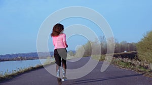 Sportive girl jogging along the river bank during sunrise or sunset. healthy lifestyle concept of athletic woman goes in
