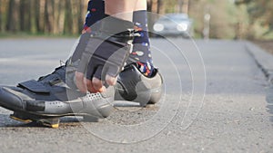 Sportive girl tightens black and grey road cycling shoes before training. Slow motion