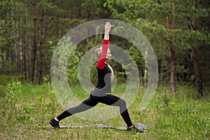 Sportive girl warming up in forest