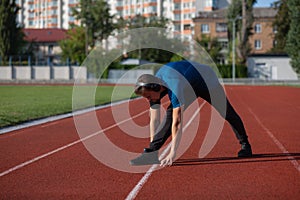 Sportive guy doing stretching and listening music