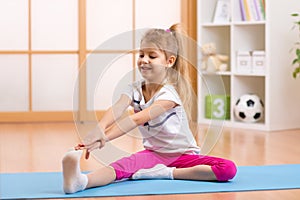 Sportive kid doing gymnastic at home