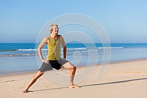 Sportive man doing gymnastics on the beach