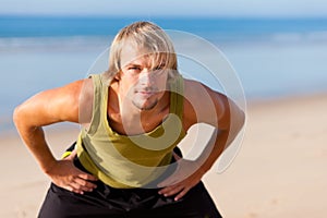 Sportive man doing gymnastics on the beach
