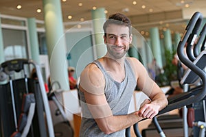Sportive man relaxing by treadmill