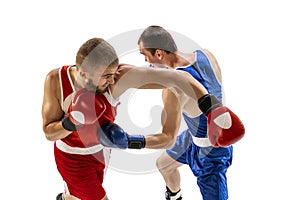 Sportive men, two professional boxer in sports uniform practicing punch isolated on white background. Concept of sport