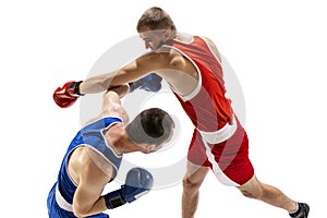 Sportive men, two professional boxer in sports uniform practicing punch  on white background. Concept of sport