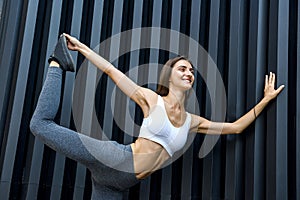 Sportive woman in city. Young girl making strength exercises on city streets