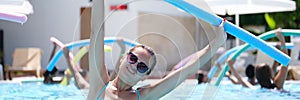 Sportive woman doing exercises in the pool, water aerobics