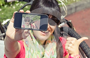 Sportive woman with fixie bike looking smartphone