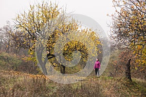Sportive woman in pink jacket stand outdoors