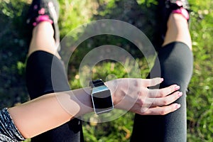 Sportive Woman After Workout Session Checking Fitness Results on Smart Watch. Top view shot of woman checking fitness progress