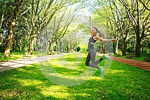 Sportive young fitness woman jumping in summer park